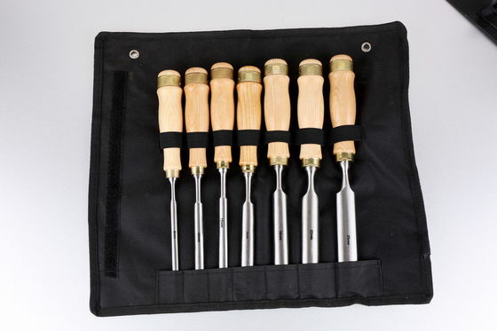 Mano che scolpisce lo scalpello di legno di giro del tornio del semicerchio di legno dei set di strumenti